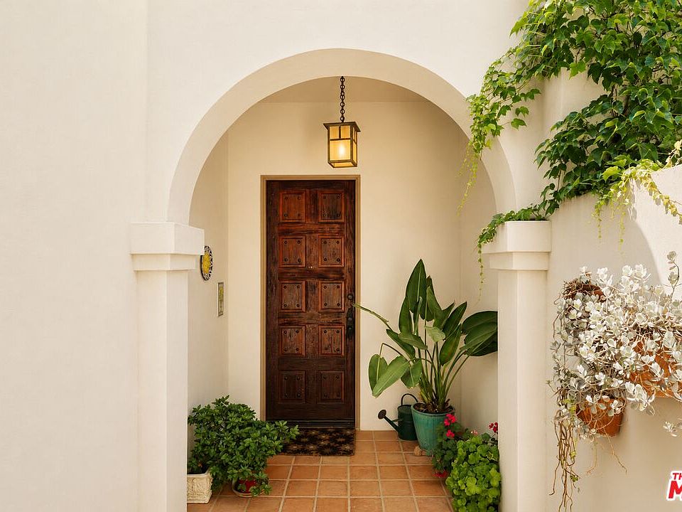 Warm arched entry with a carved wood front door